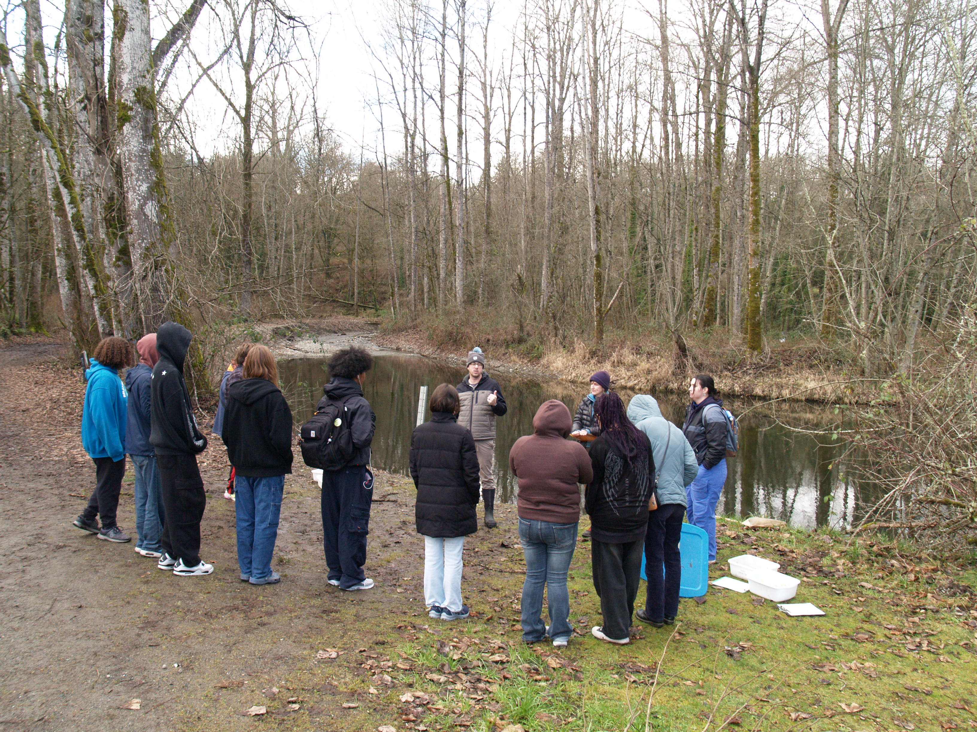 High school interns gathered together next to a creek